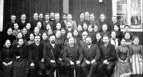 Vanha valokuva. Opiston ensimmäisenä lukuvuonna opiskelijoita oli kaikkiaan 40. Opiskelijoiden lisäksi kuvassa on opiston luottamushenkilöstöä ja keskellä opiston perustaja ja ensimmäinen rehtori Niilo Liakka. Avajaisia vietettiin 7.11.1892.